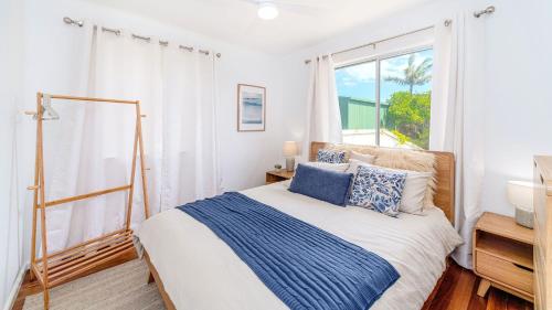 a bedroom with a bed and a large window at Sea La Vie in Brooms Head