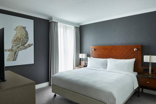 a bedroom with a bed and a bird painting on the wall at London Heathrow Marriott Hotel in Hillingdon