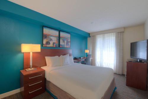 1 dormitorio con 1 cama grande y pared azul en Residence Inn Atlanta Buckhead/Lenox Park, en Atlanta