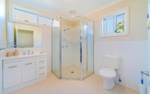 a bathroom with a shower and a toilet and a sink at Casa della vista - Beach front location in Brooms Head