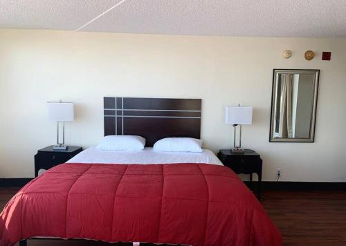 a bedroom with a large red bed with two lamps at Atlantic Palace Beachfront Ocean View in Atlantic City