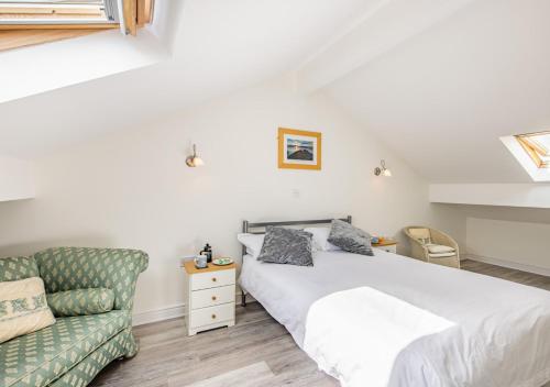 a bedroom with a bed and a green couch at Annalie in Abersoch