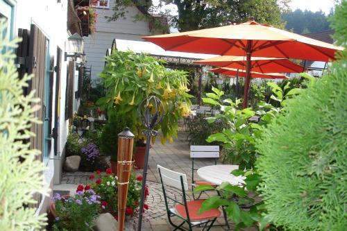 a patio with a table and an umbrella and chairs at Landhaus Goldenes Kreuz in Leutkirch im Allgäu