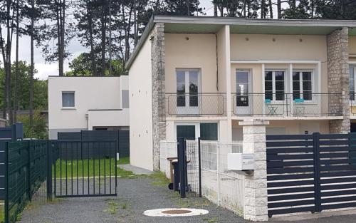 una casa blanca con una valla negra en La Patalisse, maison type 3 et jardin, en Joué-lès-Tours