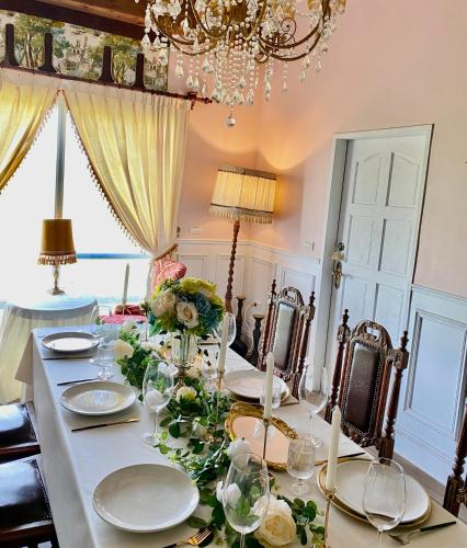 a dining room table with glasses and flowers on it at 法國小古堡-Chateau de France in Wujie