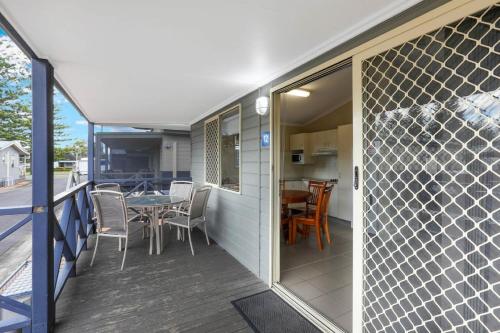 a balcony of a house with a table and chairs at Reflections Tuncurry - Holiday Park in Tuncurry