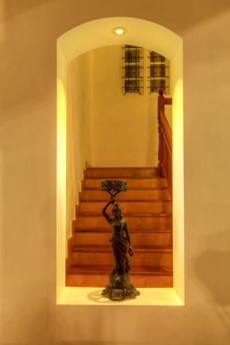 a statue of a woman holding an umbrella in front of stairs at The Fort Bungalow in Cochin