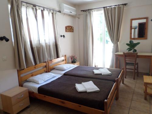 a bedroom with two beds with white towels on them at Tina Hotel in Chania Town