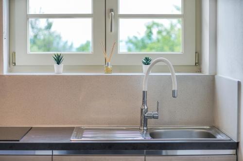 a kitchen with a sink and two windows at TEONA Luxury Apartment with terrace in Sali