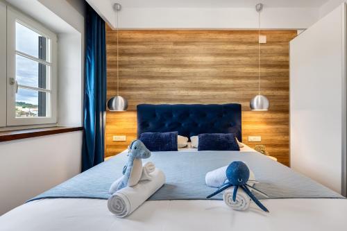 une chambre avec un grand lit et une tête de lit bleue dans l'établissement TEONA Luxury Apartment with terrace, à Sali