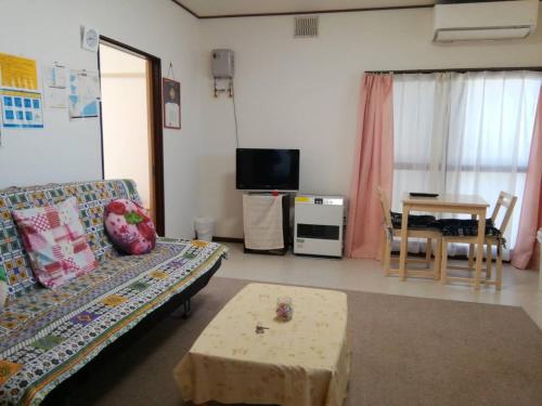 a living room with a couch and a table at Corpo Marika C in Hakodate