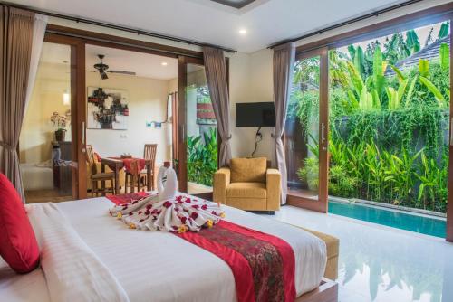 a bedroom with a large bed and a pool at Aishwarya Villa, Bali in Ketewel