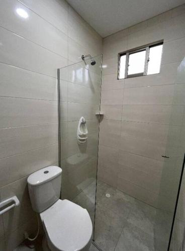 a bathroom with a toilet and a glass shower at Acogedor aparta/estudio al norte cc viva in Barranquilla