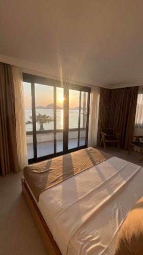 a bedroom with a large bed with a view of the ocean at Blue Point Hotel Yalikavak in Yalıkavak