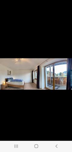 a bedroom with a bed and a large window at Relax.Land 2 Apartments (13 persons) Grinzens in Grinzens