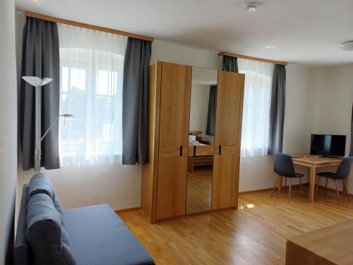 uma sala de estar com um grande armário de madeira e uma secretária em Gasthof Sturmmühle em Saxen