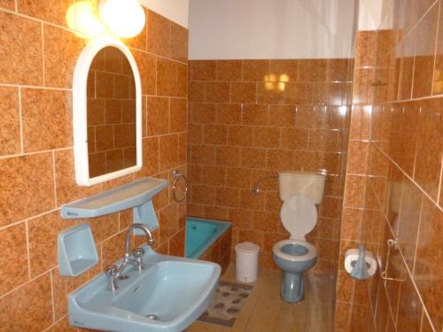 a bathroom with a sink and a toilet and a mirror at Vasilis Place Ιos in Ios Chora