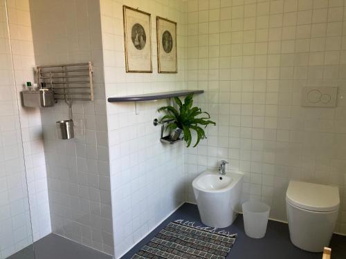 a bathroom with a toilet and a sink at The Casa Blu dependance La Casa Gialla in Tricesimo