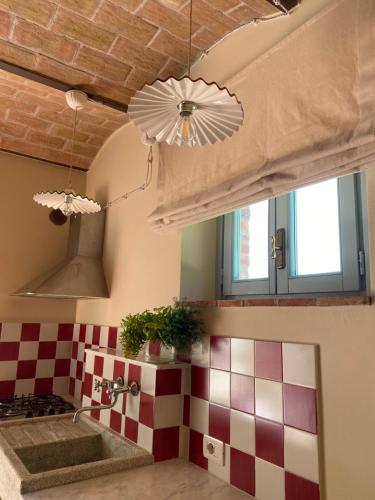 una cocina con una pared a cuadros rojo y blanco en Il Borghetto Andrea Tafi, en Lamporecchio