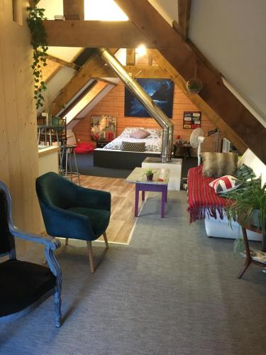 an attic room with a couch and a bed at Chez Fred avec vue sur le Château in Angles-sur-lʼAnglin