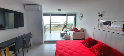 een woonkamer met een rood bed en uitzicht op de oceaan bij Cap d'Agde Naturiste Héliopolis C SEARENA in Cap d'Agde
