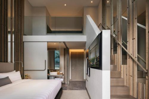 a bedroom with a bed and a staircase in a room at Pan Pacific Orchard in Singapore