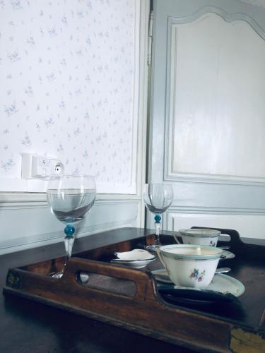 - un plateau avec des verres à vin et des bols sur une table dans l'établissement les chambres fleuries, à Saint-Benoît-du-Sault
