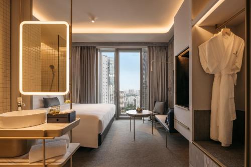 a hotel room with a bed and a sink and a bathroom at Pan Pacific Orchard in Singapore
