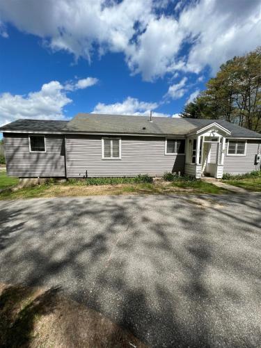 a white house with a driveway in front of it at MARY'S LAKEVIEW - LIMIT 10 home in North Sebago