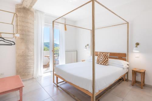 a bedroom with a four poster bed and a balcony at Tenuta dei Normanni in Salerno