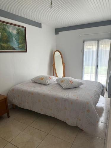 a bedroom with a bed with a mirror on it at L'art de vivre conjugué au calme in Balloy