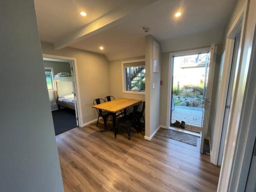 a dining room with a table and chairs and a window at Pudding Hill Lodge & Chalets in Mount Hutt