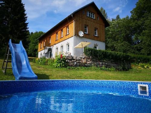 a house with a swimming pool in front of a building at Dukát Kořenov in Kořenov