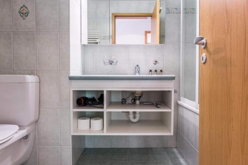 a bathroom with a sink and a toilet at Apartment Dolce Vita - GRIWA RENT AG in Grindelwald