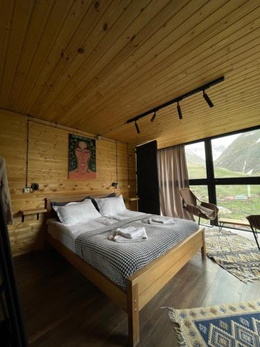 a bedroom with a bed in a wooden room at Pirdapira in Jut'a