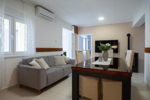 a living room with a couch and a table at Holiday Home Ines in Vrsi