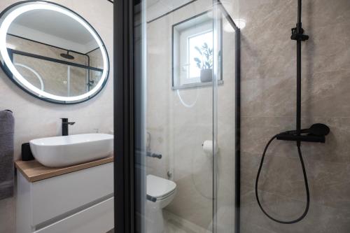a bathroom with a shower and a sink and a mirror at Holiday Home Ines in Vrsi