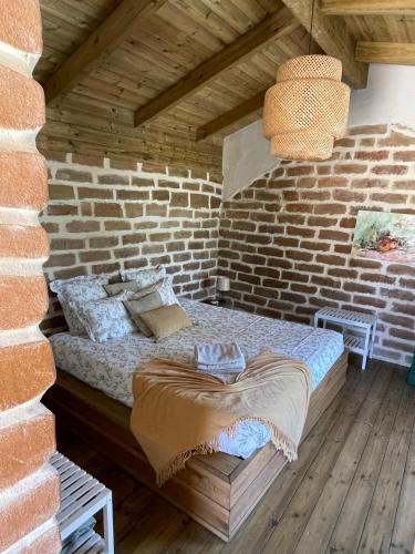 a bedroom with a bed in a brick wall at SeaHouseNature in Porto Covo