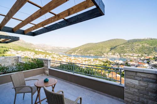 - une vue depuis le balcon d'une maison avec une table et des chaises dans l'établissement Apartments Villa Arcadia, à Dubrovnik