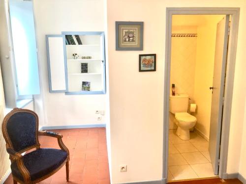 a bathroom with a chair and a toilet at Les Florentines in Carcassonne