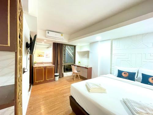 a hotel room with a bed and a desk at WellQuest Wellness Ladprao Soi 1 in Bangkok