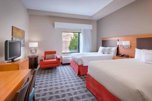 una camera d'albergo con due letti e una televisione di TownePlace by Marriott Suites Elko a Elko