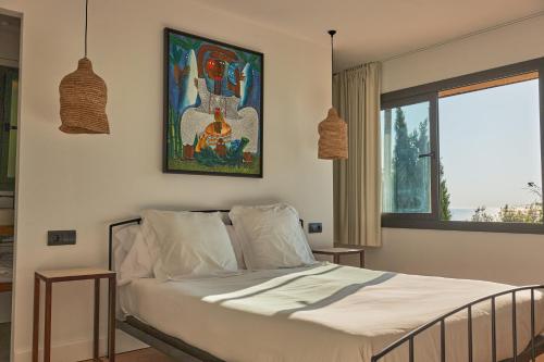ein Schlafzimmer mit einem Bett und einem Wandgemälde in der Unterkunft L'Aixart Aiguablava Hotel in Begur