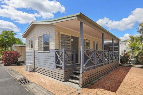 a tiny house with a large deck on a street at Reflections Tuncurry - Holiday Park in Tuncurry