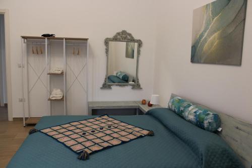 a bedroom with a blue bed and a mirror at Coco & Lisbeth bed and breakfast in Brindisi