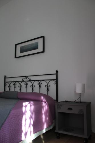 a bedroom with a purple bed with a picture on the wall at Coco & Lisbeth bed and breakfast in Brindisi