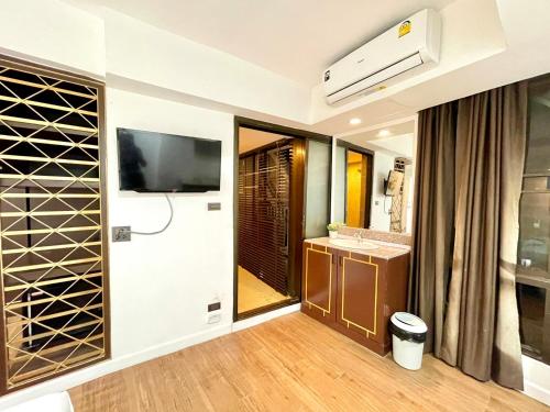 a bathroom with a television and a wine cellar at WellQuest Wellness Ladprao Soi 1 in Bangkok