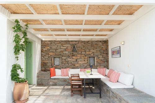 a patio with a table and chairs and a stone wall at Casa Xyla-sunset view villa in Melissaki