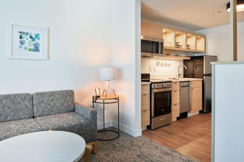 a living room with a couch and a kitchen at TownePlace Suites by Marriott Hixson in Hixson