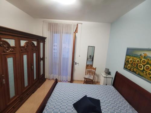 1 dormitorio con 1 cama y una pintura en la pared en Casa Zia Gianna en Otranto